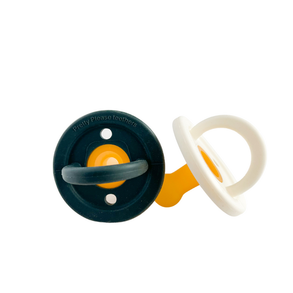 Pretty Please Teethers (Modern Pacifier) - The PPT Modern Pacifier makes a beautiful addition to your collection of baby essentials. Our thoughtfully designed pacifiers are made to soothe and comfort your little ones, while keeping a natural, modern and minimalist style and satisfying their instinctive sucking reflex.  Set includes New 1 Coconut Milk pacifier & 1 Navy pacifier 